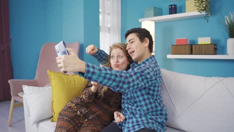 Happy-and-smiling-mother-and-young-son-taking-pictures-with-the-phone's-front-camera.